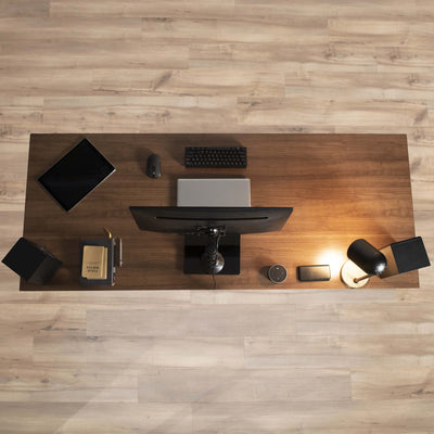 Modern office space with a monitor mount and other sleek office desk items.