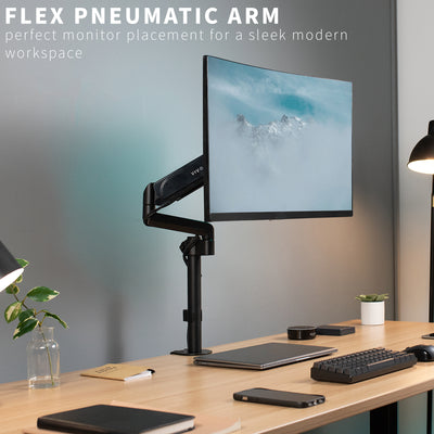 A sleek pneumatic arm monitor mount in a modern desk space.